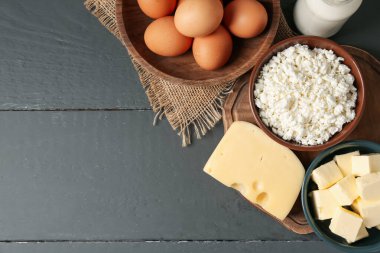 Gri ahşap masa üzerinde farklı süt ürünleri ve yumurtalar, düz yatak. Metin için boşluk