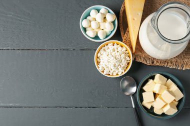 Gri ahşap masada farklı süt ürünleri var. Metin için boşluk