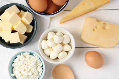 Farklı süt ürünleri ve yumurtalar beyaz ahşap masa üzerinde, düz yatıyordu