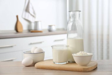 Mutfaktaki ahşap masada farklı süt ürünleri ve yumurtalar.