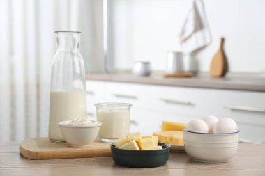 Mutfaktaki ahşap masada farklı süt ürünleri ve yumurtalar.