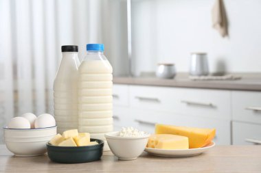 Mutfaktaki ahşap masada farklı süt ürünleri ve yumurtalar.