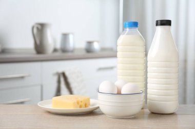 Mutfaktaki ahşap masada farklı süt ürünleri ve yumurtalar.