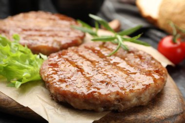 Lezzetli hamburger köfteleri ve baharatlar masada, yakın plan.