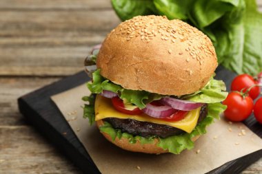 Tahta masada köfte ve peynirli lezzetli hamburger, yakın plan. Metin için boşluk