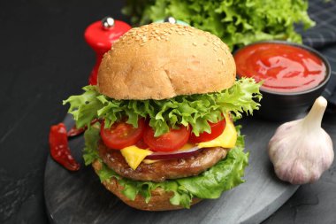 Köfteli lezzetli hamburger, siyah masada servis ediliyor, yakın plan.