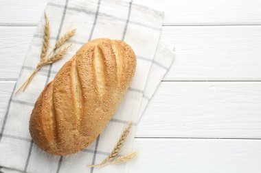 Taze ekmek somunu ve çiviler beyaz ahşap masada, düz yerde. Metin için boşluk