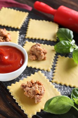 Ahşap masada ravioli bolonez yapıyorum, yakın plan.