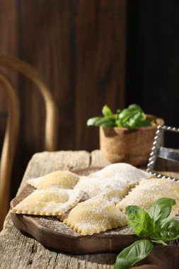 Ahşap masada pişmemiş ravioli ve fesleğen. Metin için boşluk