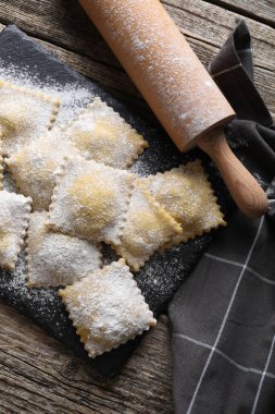 Pişmemiş ravioli ve merdane ahşap masa, üst manzara.