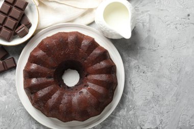 Lezzetli kek, gri masada çikolata ve süt parçaları, düz yatak. Metin için boşluk