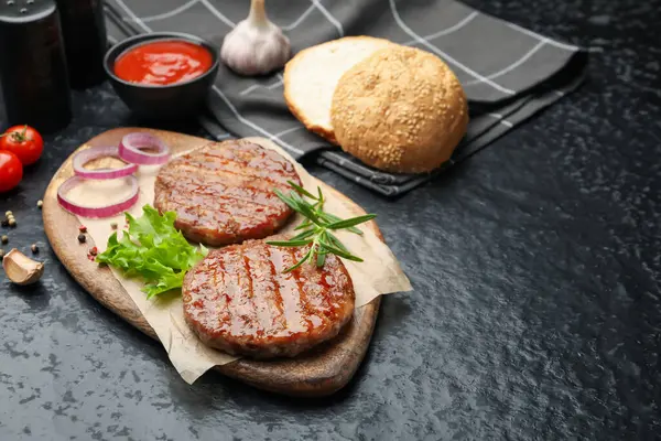 Lezzetli hamburger köfteleri ve baharatlar siyah masada. Metin için boşluk