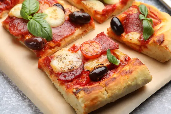 Gri masada lezzetli ev yapımı pizza, yakın plan.