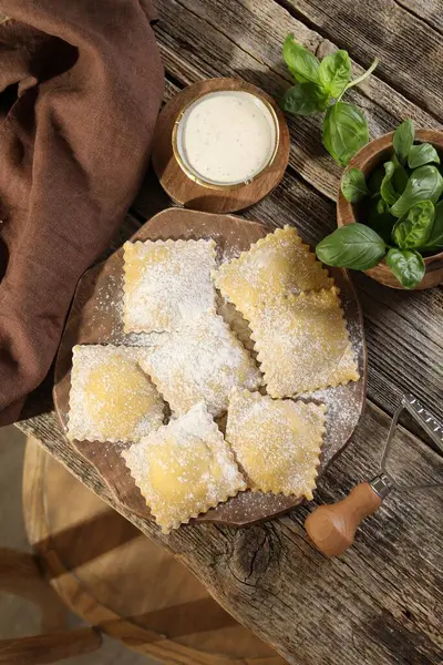 Ahşap masada pişmemiş mantı ve fesleğen.