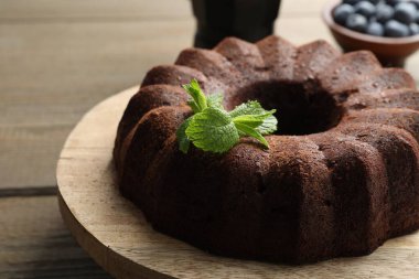 Naneli çikolatalı kek ve ahşap masada yaban mersini, yakın plan.