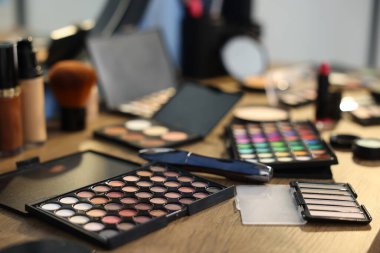 Kapalı alanda, ahşap masada farklı makyaj ürünleri.