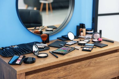 Farklı makyaj ürünleri ve kapalı mekandaki gösteriş fırçaları, yakın çekim