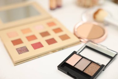 Beyaz masada farklı makyaj ürünleri, yakın plan.