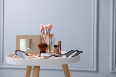 Beyaz masa içerisindeki farklı makyaj ürünleri, metin için yer