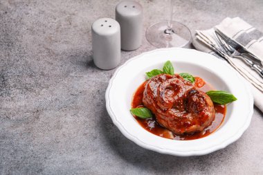 Geleneksel ossobuco yemeği ve biftek gri masada servis edilir. Metin için boşluk