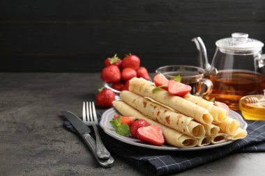 Çilekli lezzetli krepler ve gri masada nane şekeri. Metin için boşluk