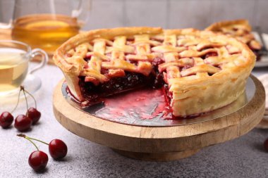 Gri desenli masada vişneli turta ve böğürtlen. Yakın plan.