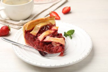 Lezzetli çilekli turta ve beyaz ahşap masada böğürtlen, yakın plan.