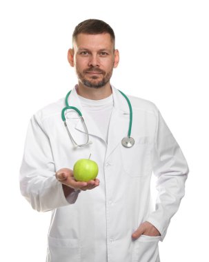 Beyaz arka planda yeşil elmalı ve steteskoplu beslenme uzmanı.