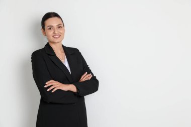 Hafif arka planda takım elbiseli kendine güvenen bir iş kadını. Metin için boşluk