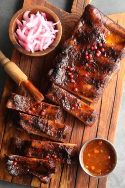 Lezzetli pirzola, soğan ve sos gri masada, üst tarafta.