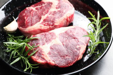 Yemek masasında çiğ et ve baharat parçaları, yakın plan.