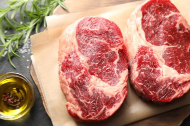 Siyah masanın üstünde çiğ et ve baharat parçaları.