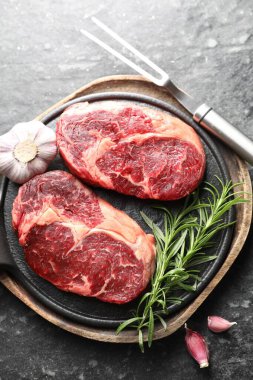 Çiğ et, baharat ve çatal. Koyu masada, düz yerde.