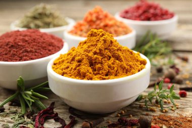 Ahşap masada farklı aromatik baharatlar, yakın plan.