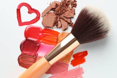 Beyaz arka planda farklı kozmetik ürünleri ve makyaj fırçası, düz konum