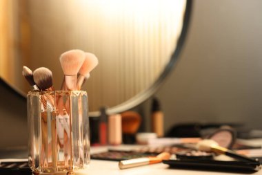 Tuvalet masasında fırçalar ve kozmetik ürünler, yakın plan.