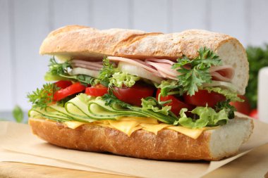 Jambonlu, peynirli ve sebzeli baget sandviç. Arka planda bulanık gri, yakın plan.