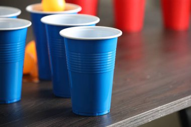 Bira pong oyunu. İçkili plastik bardaklar ve toplar ahşap masada, yakın plan. Metin için boşluk