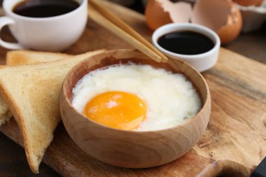 Yarısı haşlanmış yumurta, soya sosu, yemek çubukları, kahve ve kızarmış ekmek, yakın plan. Geleneksel Asya kahvaltısı
