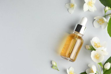 Kozmetik ürünleri ve yasemin çiçekleri arka planda, düz yerde. Metin için boşluk