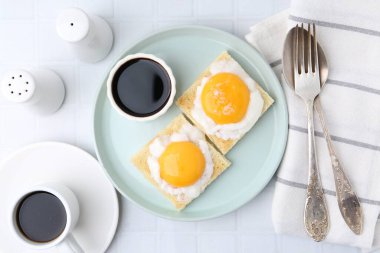 Lezzetli kaya tostları, kaynamış yumurtalar beyaz fayanslı masada servis edilir. Geleneksel Asya kahvaltısı