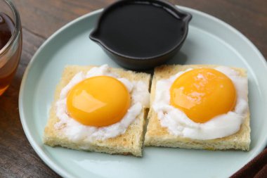 Ahşap masada yarım haşlanmış yumurtalı lezzetli kaya tostları, yakın çekim. Geleneksel Asya kahvaltısı
