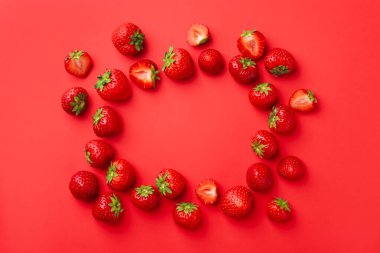 Kırmızı arka planda taze olgun çilek çerçevesi, düz. Metin için boşluk