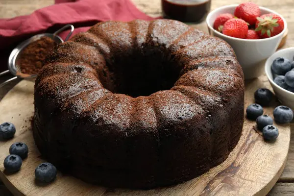 Ahşap masada yaban mersinli lezzetli çikolatalı kek, yakın plan.