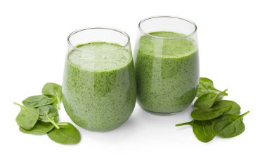 Lezzetli smoothie ve ıspanak yaprakları beyaz üzerine izole edilmiş.