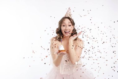 Doğum günü kutlaması. Beyaz arka planda kek ve konfeti olan kadın.