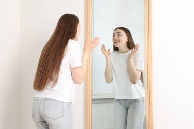 Güzel bir kadın aynada kendine bakıyor.