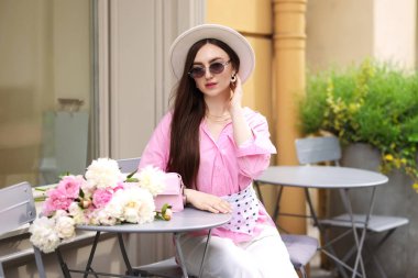 Açık kafede güzel şakayıkları olan şık bir kadın.