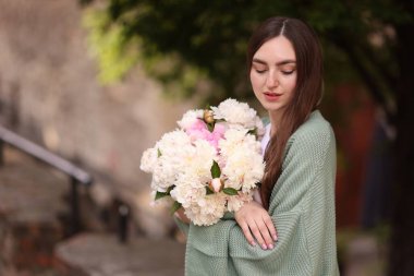 Şehir caddesinde bir buket güzel şakayığı olan çekici bir kadın. Metin için boşluk