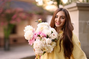 Şehir caddesinde elinde şakayık demeti olan bir kadın. Metin için boşluk